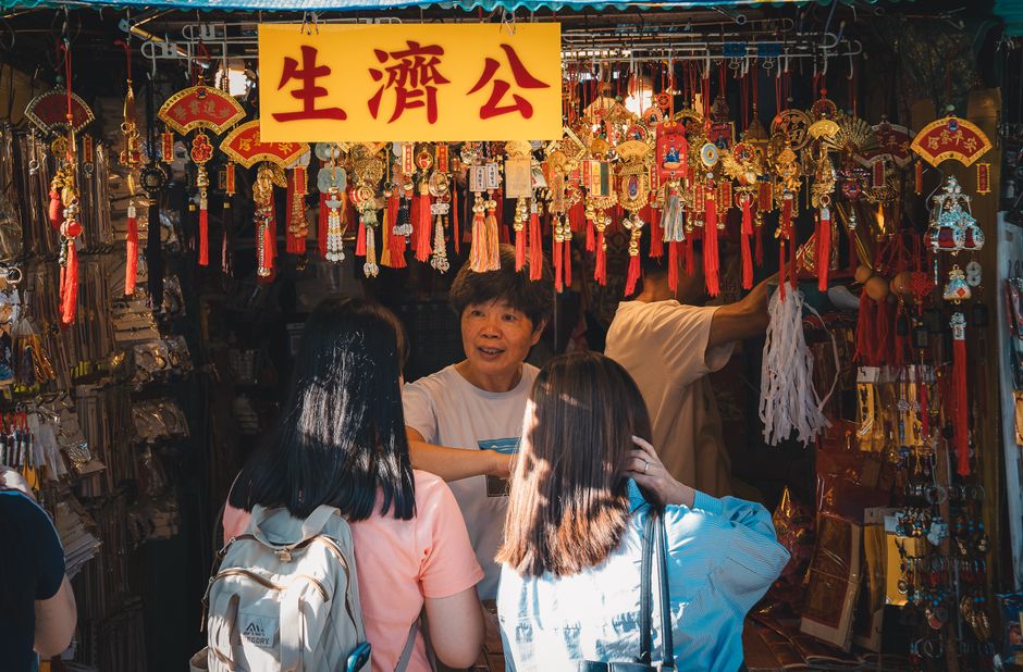Vibrant Hong Kong market scene with people shopping for traditional souvenirs.