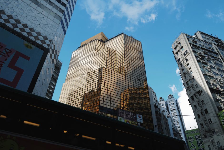 Stunning low angle view of reflective skyscrapers in Hong Kong against a clear blue sky.